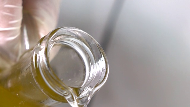 慢镜头特级初榨橄榄油被倒出一个透明的玻璃瓶视频下载