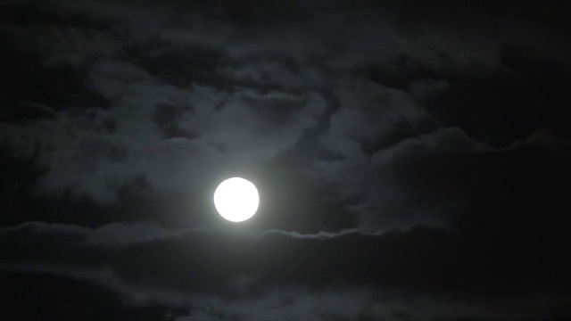 明亮的月盘穿过厚厚的云层，就像善良试图战胜邪恶视频素材