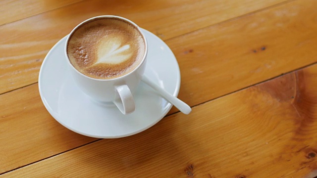 拿铁咖啡准备喝在咖啡馆的木桌上视频下载