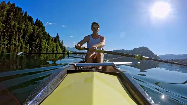 一名男子运动员与他的队友在阳光下划船视频下载