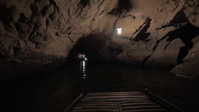 游客在越南旅游时，乘船穿过黑暗的洞穴系统视频下载