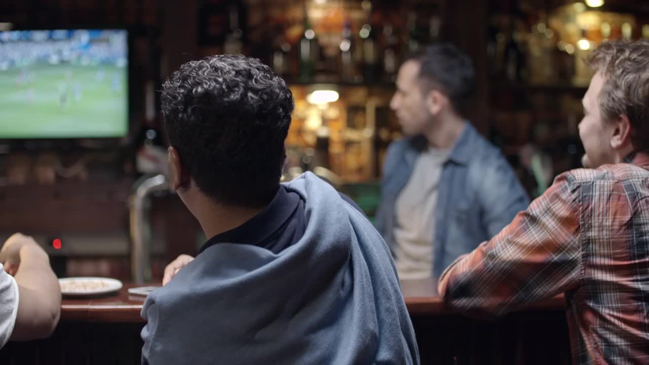 父亲和儿子在酒吧看足球视频素材