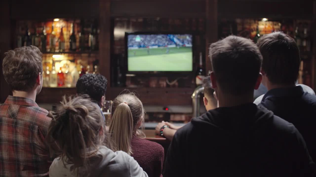 足球球迷在体育酒吧庆祝球队胜利视频素材