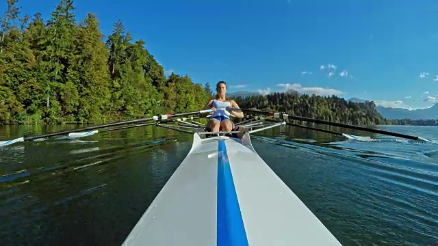 女运动员在阳光明媚的湖面上进行双桨划水视频下载