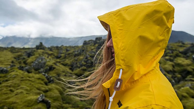 年轻的女游客正在欣赏冰岛的苔藓景观视频素材