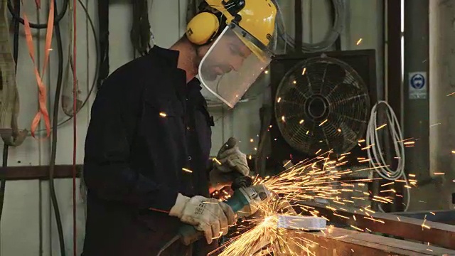 在金属车间使用金属磨床的工人视频素材