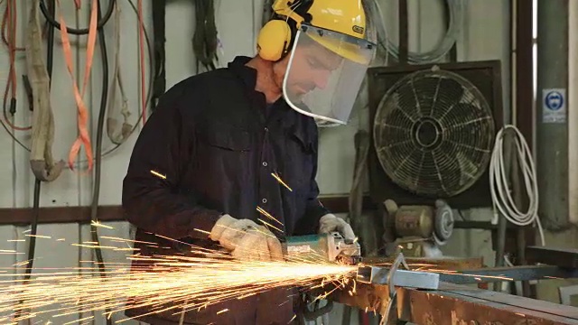 在金属车间使用金属磨床的工人视频素材