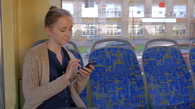 乘坐有轨电车并使用智能手机的女性视频素材