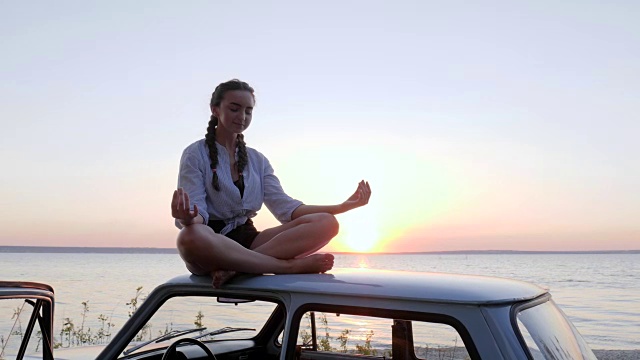 海边夕阳下车顶上女孩的沉思，河岸上机器上女性的放松，夏日之旅，快乐之旅视频下载