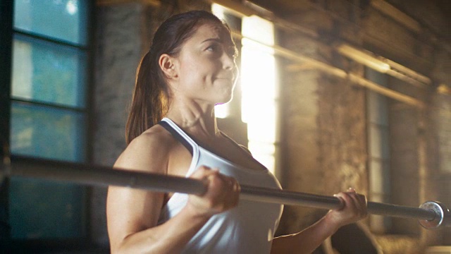 强壮的女运动员举起沉重的杠铃作为她的交叉健身健身馆锻炼的一部分。视频素材