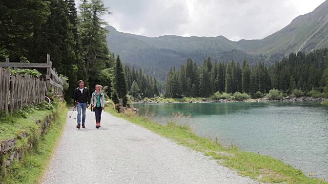 成熟的成年夫妇，走过风景优美的自然景观和湖泊视频素材