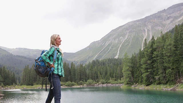 成熟的成年女子在湖边欣赏优美的自然景观视频素材