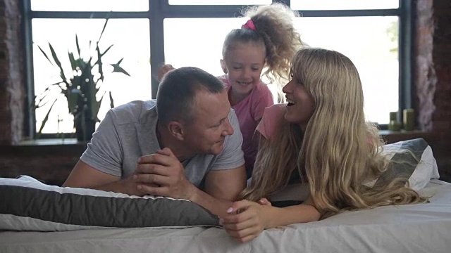 迷人的年轻家庭和女儿在卧室视频素材
