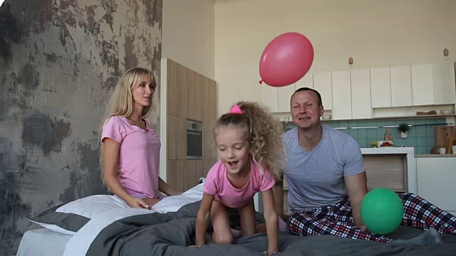 欢乐的一家人在床上玩气球视频素材