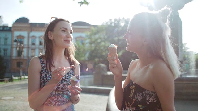 两个女性朋友在一个城市吃冰淇淋。视频素材