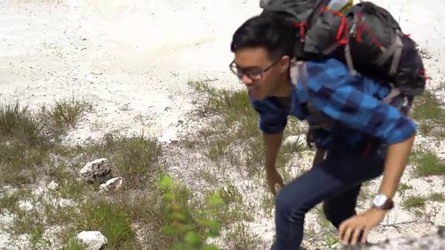 亚洲快乐攀登者举起他的手臂为他的成功视频素材