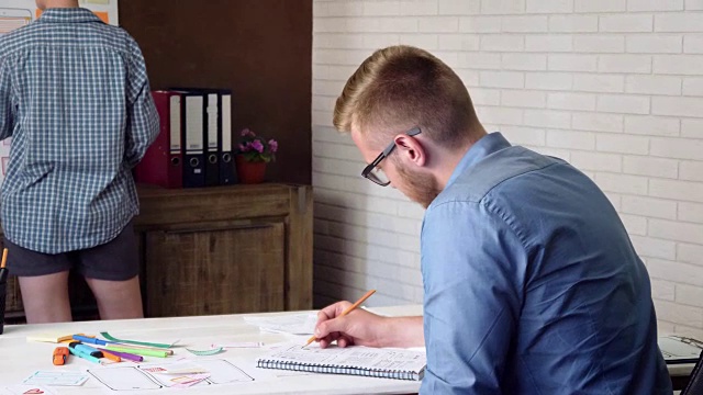 UX设计师在他的笔记本上画一个新应用程序的原型视频素材