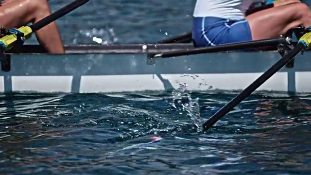运动员在阳光下划着桨穿过水面视频素材