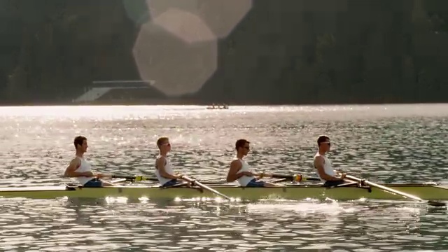 日落时分，四名男运动员划着船横渡湖面视频素材