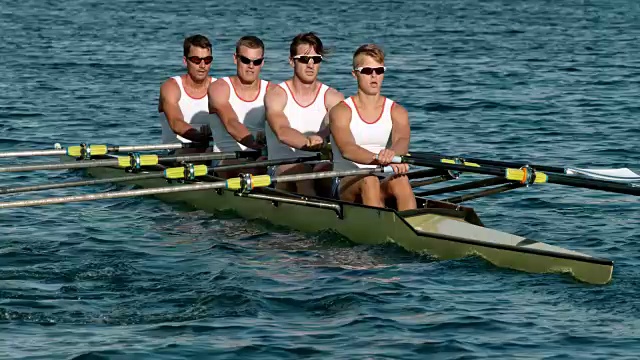 下午晚些时候，四名男子运动员划着桨横渡水面视频素材