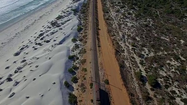 在海滩上的移动火车上空的天线视频下载