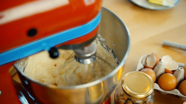 红色搅拌机在大碗里搅拌面团和配料。糕点师做甜点视频素材