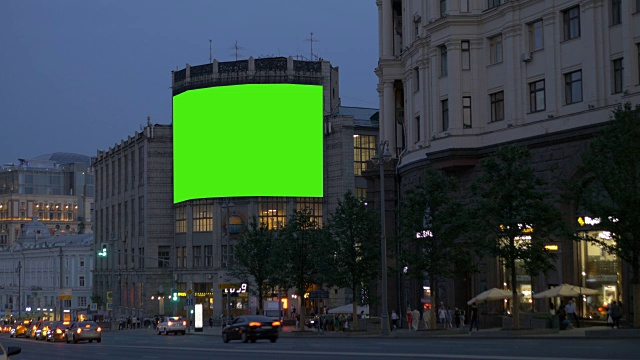 一个巨大的广告牌，在一个古老的建筑上，在一条繁忙的街道上。绿色的屏幕。视频素材