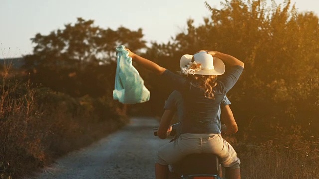 一对夫妇骑着摩托车穿过乡村。视频素材