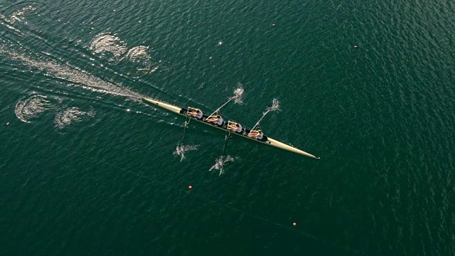 在阳光下，跟随运动员划着无舵手四人艇横渡湖面视频素材
