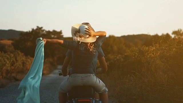 一对夫妇骑着摩托车穿过乡村。视频素材