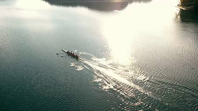 空中运动员在没有舵手的四人在阳光下滑行过一个湖视频下载