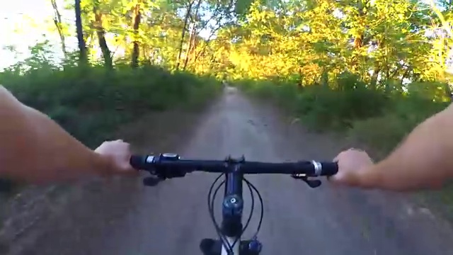 黄昏时分，人们在一条宽阔的土路上骑自行车视频素材
