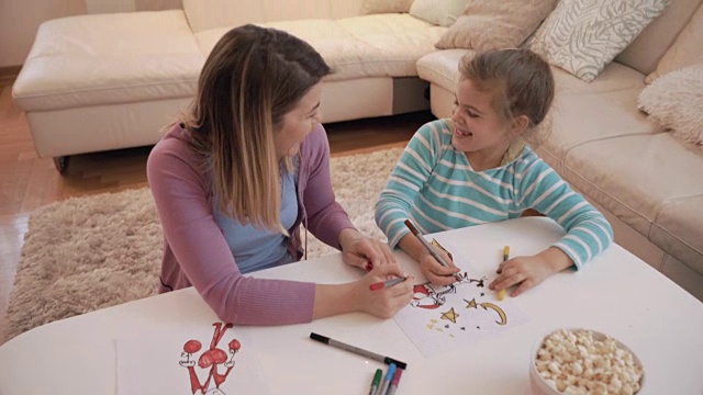 母亲和女儿花一个创造性的时间在家里，同时画画和交流。视频素材