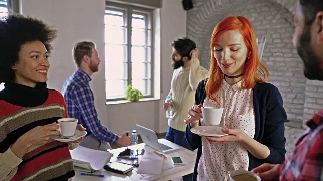 年轻的创业团队在休闲办公室的咖啡休息时间交流。视频素材