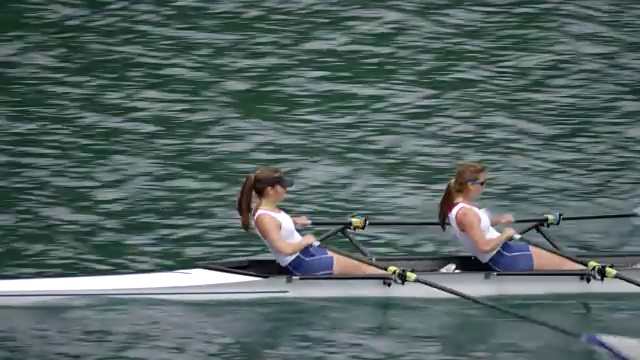 两个女运动员划着水横渡湖面视频素材