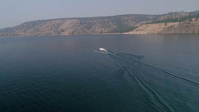 无人机拍摄的人在罗斯福湖的小船后面滑水视频素材