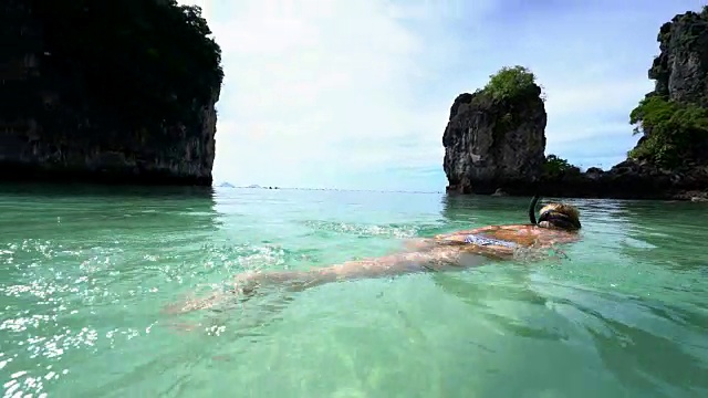 一名女子在泰国温暖的绿松石水中浮潜视频素材