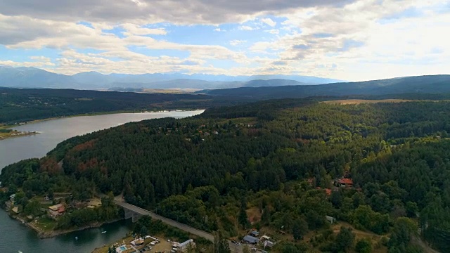 无人机在一个宏伟的乡村湖泊和小型度假胜地上空拍摄视频下载