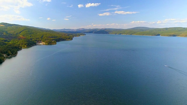 无人机飞行显示拍摄了一个美丽的乡村湖泊与一艘帆船在它视频下载
