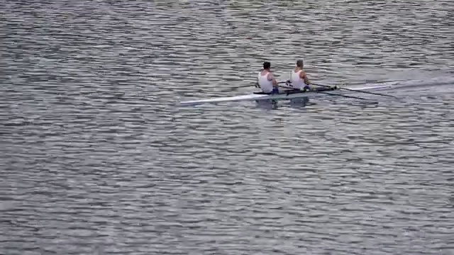 男子运动员在湖上划着双桨视频素材