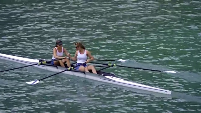 女运动员在阳光明媚的湖面上进行双桨击掌视频素材