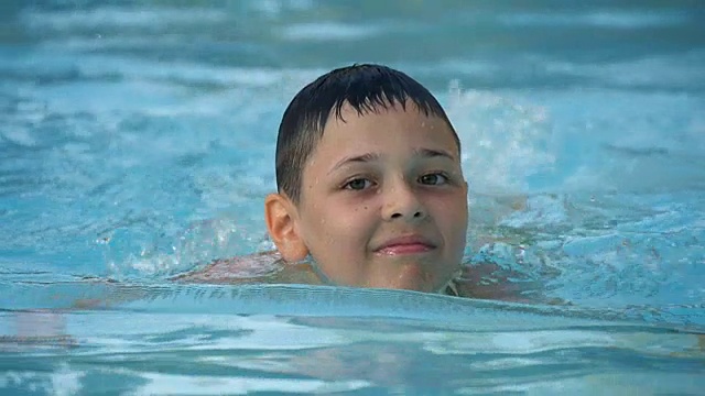 快乐的小男孩愉快地在游泳池水上公园戏水视频素材