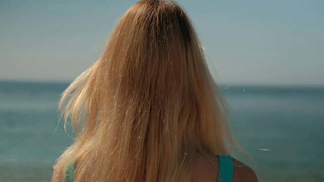 那个金发女人背对着海岸站着视频素材