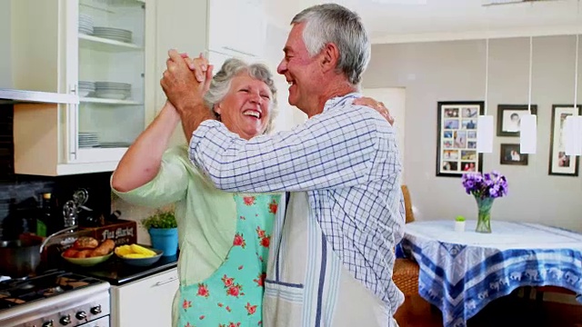 浪漫的高年级情侣在厨房跳舞视频素材