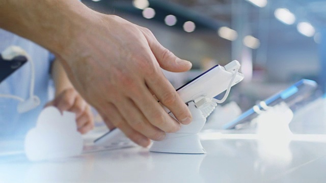 在电子商店的特写镜头，顾问展示平板电脑给消费者。视频素材