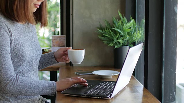 女人用她的笔记本电脑在咖啡馆放松时间，摄影视频素材