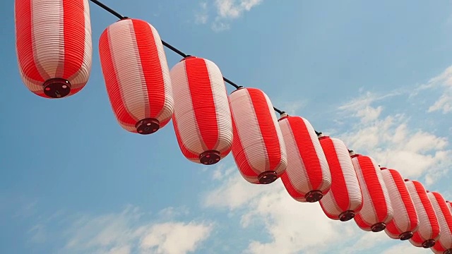 纸上红白相间的日本灯笼挂在蓝天的背景上视频素材