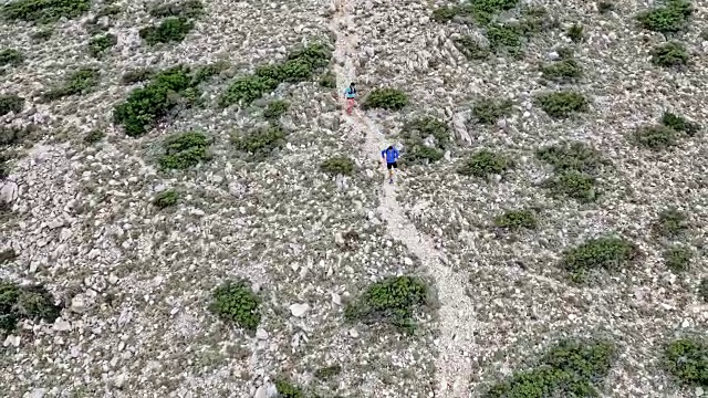 两名跑步者在一条多岩石的山路上跑步视频素材