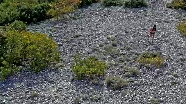 空中女跑步者跑上岩石山的小径俯瞰亚得里亚海和附近的岛屿视频素材