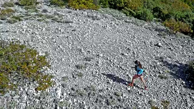 空中女跑步者在阳光下跑上岩石山视频下载